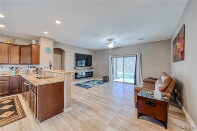 Kitchen with ceiling fan, light stone counters, an
