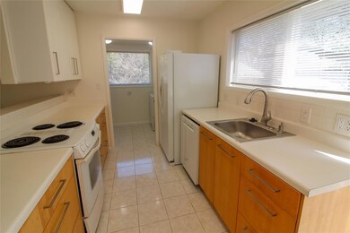 Kitchen with light countertops, white appliances,