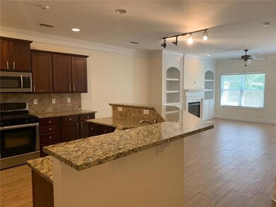 Kitchen with appliances with stainless steel finishes, a sink, visible vents, a ceiling fan, and a center island with sink