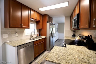Kitchen with light stone counters, tasteful backsp