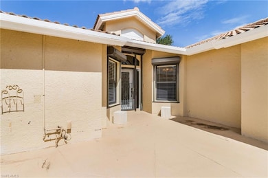 View of exterior entry featuring stucco siding and a patio area