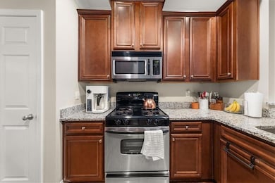 Kitchen featuring stainless steel appliances and light stone counters