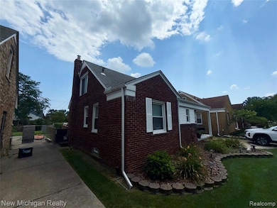 View of side of home featuring brick siding, a chimney, and a yard