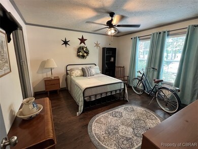 Bedroom with wood finished floors, crown molding,
