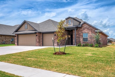 Craftsman-style home with brick siding, a garage, a front lawn, driveway, and board and batten siding