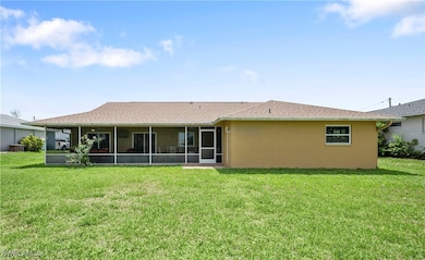 Rear view of house featuring a sunroom, a yard, st