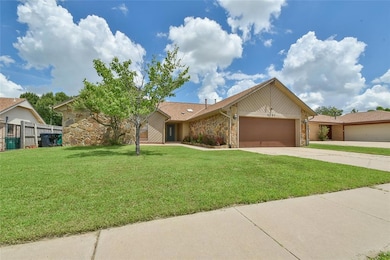 View of front of property with stone siding, an attached garage, and driveway