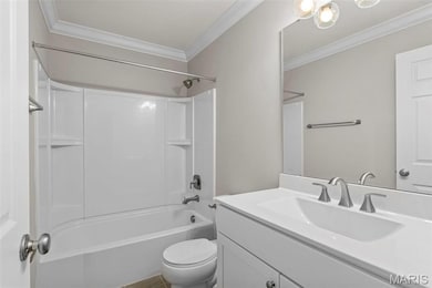 Full bathroom featuring bathing tub / shower combination, crown molding, vanity, and toilet