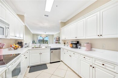 Kitchen with white appliances, sink, white cabinet