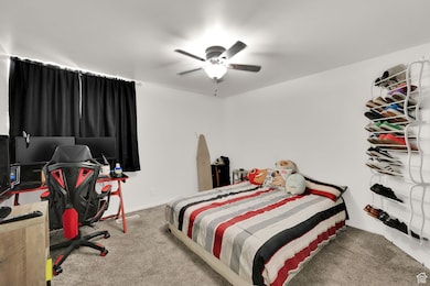 Bedroom featuring carpet floors, an office area, and ceiling fan