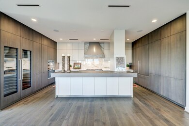 This contemporary Chef's kitchen has it all, including two wine cooler towers, Miele stainless appliance package with custom vent hood, and tons of storage in Eggersmann cabinets designed for this specific space to maximize storage.