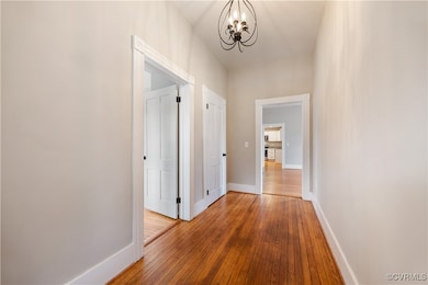 Corridor featuring baseboards, wood-type flooring,
