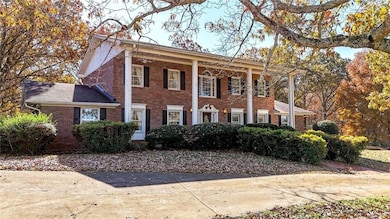 Greek revival house featuring brick siding and a porch