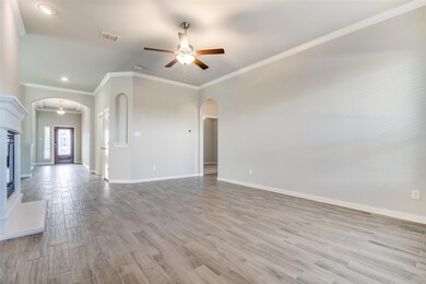 Unfurnished living room with ornamental molding, light hardwood / wood-style floors, and ceiling fan