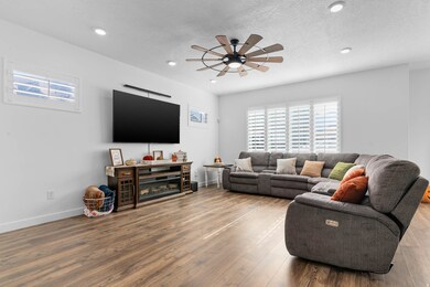 Family room featuring plenty of natural light, ceiling fan, wood finished floors, a textured ceiling, and recessed lighting
