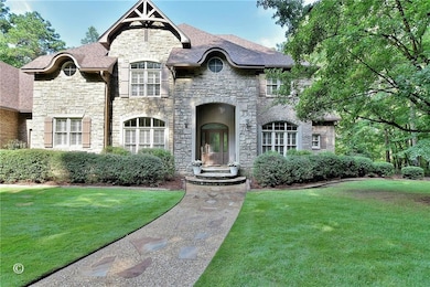 French country home featuring stone siding and a front yard