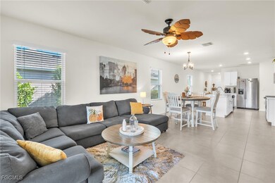 Living area with a ceiling fan, light tile patterned floors, a chandelier, and recessed lighting