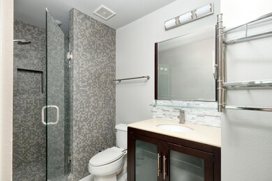 Bathroom featuring toilet, a shower stall, vanity