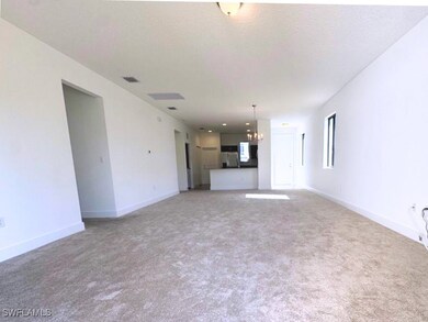 Unfurnished living room featuring baseboards, ligh