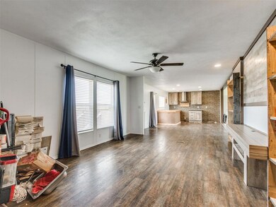 Unfurnished living room with dark wood-type flooring, a ceiling fan, and recessed lighting