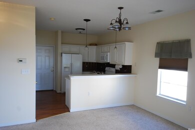 Kitchen with white appliances, backsplash, an invi