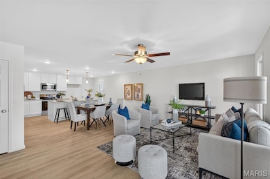 Living room with LVP flooring and a ceiling fan