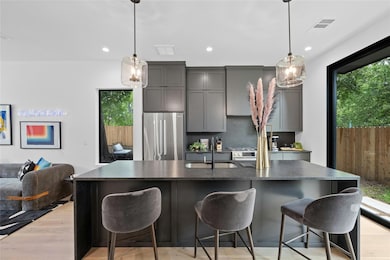 Kitchen featuring gray cabinets, an island with s