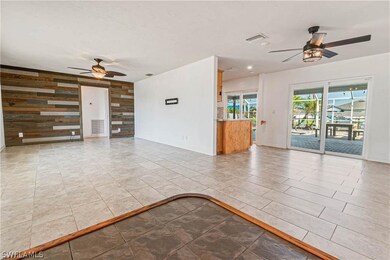 Tiled spare room featuring ceiling fan and wood walls