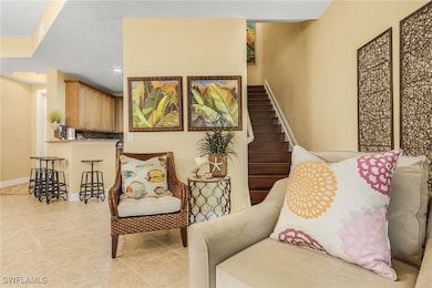 Living area with stairway, baseboards, light tile patterned floors, and recessed lighting