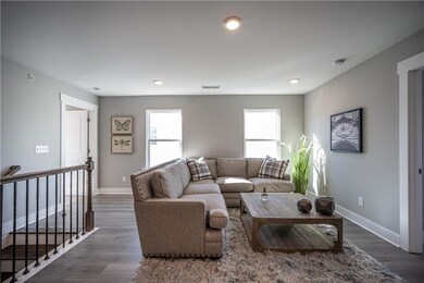 Living area with baseboards, plenty of natural light, dark wood-style flooring, and recessed lighting