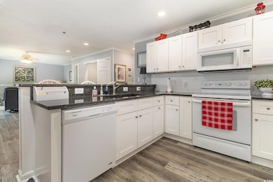Kitchen featuring white appliances, a peninsula, o