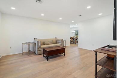 The living room has high-hat lights installed, newly installed floors, and has been recently painted.