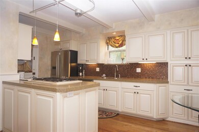 Kitchen view with wood flooring, custom cabinetry, and granite counter tops.
