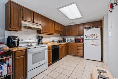 Kitchen featuring backsplash, white appliances, li