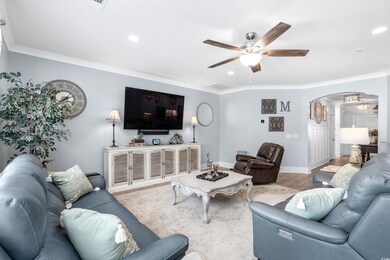 Living room with wood-type flooring, crown molding