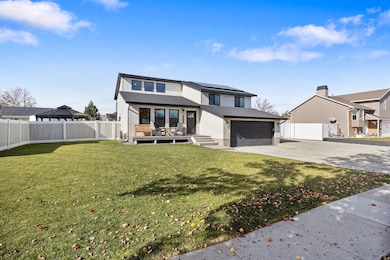 View of front of house with solar panels, a garage, concrete driveway, and a deck