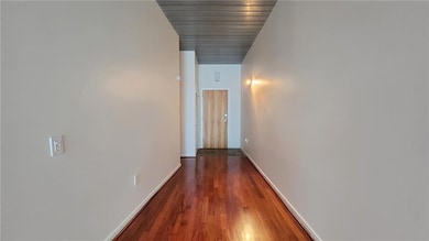 Hallway featuring baseboards and wood finished floors