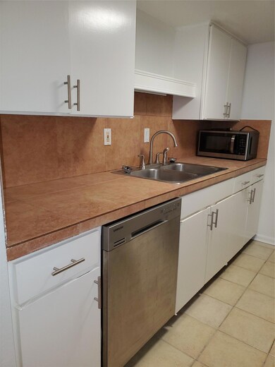 Kitchen featuring dishwasher, a sink, white cabin