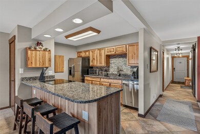 Kitchen featuring a peninsula, granite countertops, backsplash, stainless steel appliances, and recessed lighting