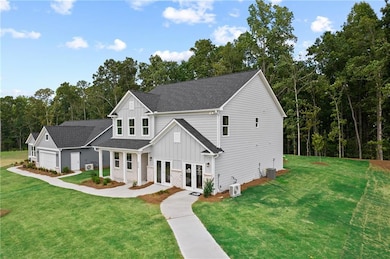Modern inspired farmhouse with board and batten siding, french doors, a front yard, and roof with shingles
