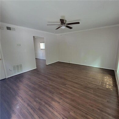 Unfurnished room with ornamental molding, dark wood-style floors, and a ceiling fan
