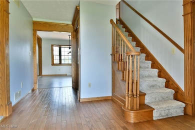 Stairs with hardwood / wood-style flooring and baseboards