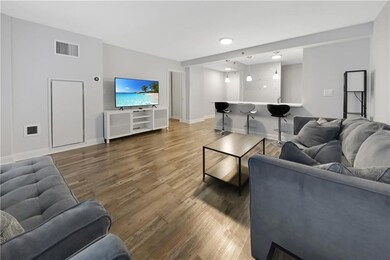 Living area with baseboards, visible vents, and wo
