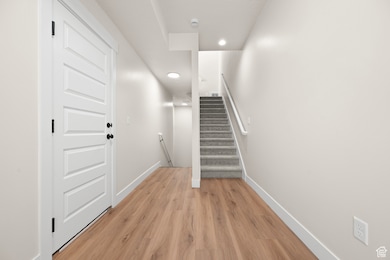 Stairway featuring wood finished floors and recessed lighting