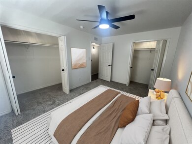 Carpeted bedroom featuring a closet and ceiling fan