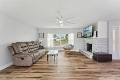 Living room with ceiling fan, a fireplace, and lig