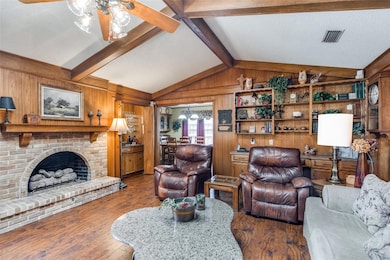 Living room featuring wooden walls, a gas fireplac