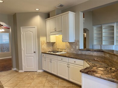 Your kitchen features a nice corner pantry, a gas cooktop, and long, beautiful granite counters. You have a breakfast bar and the kitchen opens to the living room.