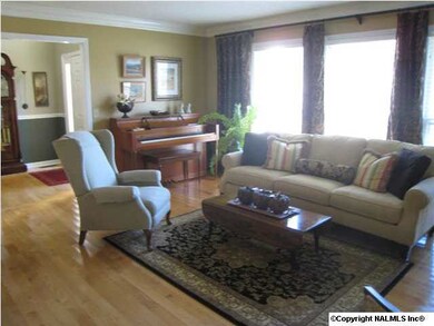 The formal living room has hardwood floors and triple front view windows for lots of fresh Sunlight