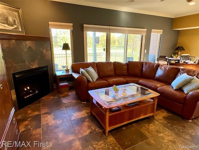 Living area with a tiled fireplace and crown molding